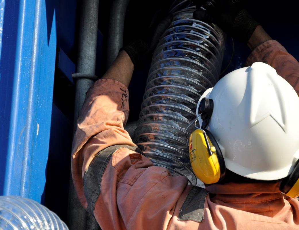 Person with helmet working with some pipes