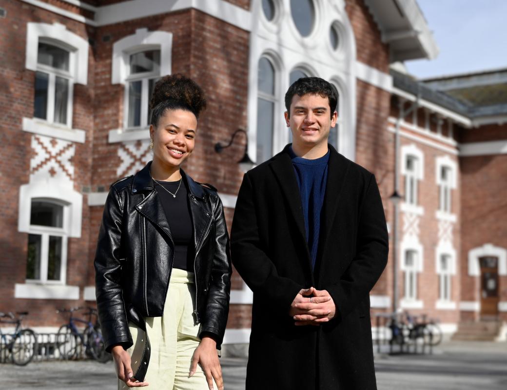 Two international students in front of a building